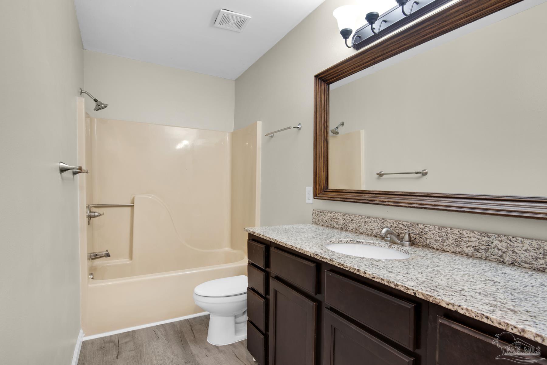 5804 Gulf Road Milton, FL 32583 - Photo 33 of 54 a bathroom with a granite countertop sink a toilet and shower