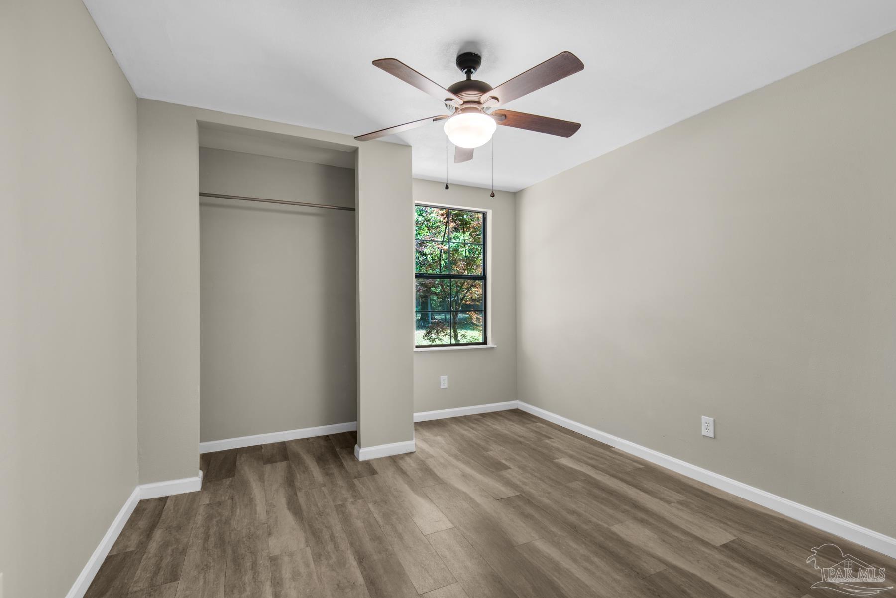 5804 Gulf Road Milton, FL 32583 - Photo 41 of 54 wooden floor in an empty room with a window
