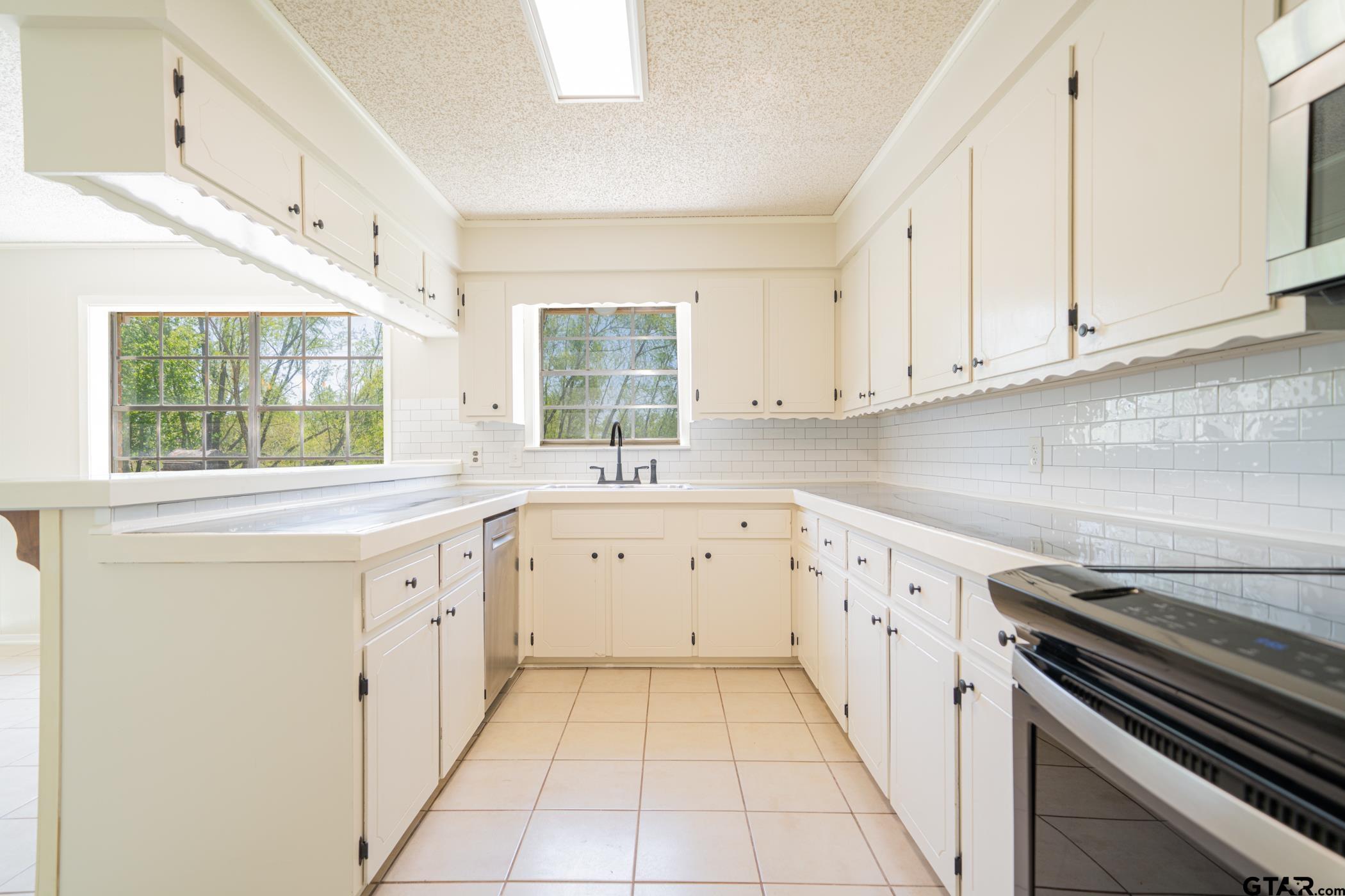 1332 Cr 4840 Mount Mount Pleasant, TX 75455 - Photo 15 of 38 a kitchen with granite countertop white cabinets and white appliances