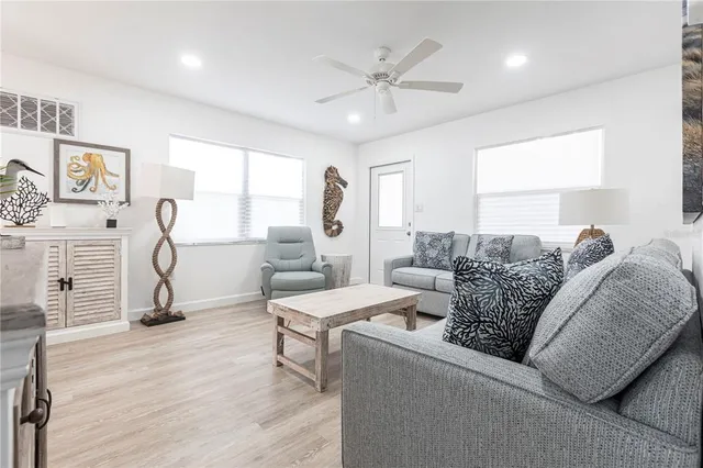 a living room with furniture a ceiling fan and a window
