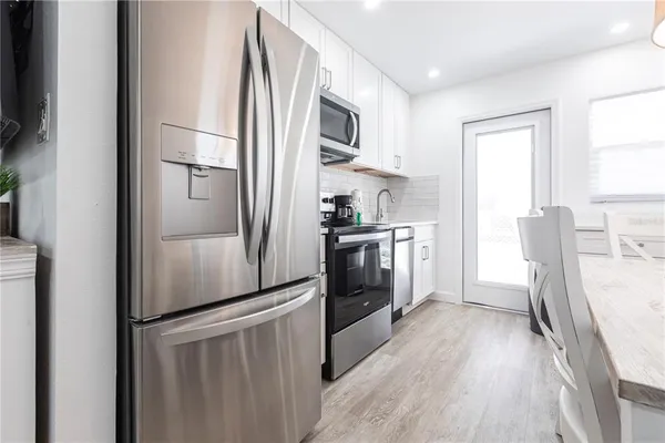 a kitchen with a refrigerator a sink dishwasher and a stove top oven