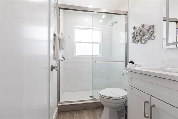 a bathroom with a sink a toilet and shower