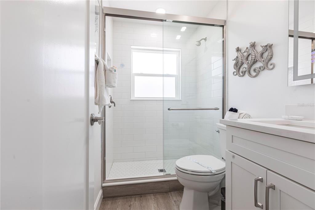 6020 Midnight Pass Road, Unit 7 Sarasota, FL 34242 - Photo 9 of 18 a bathroom with a sink a toilet and shower