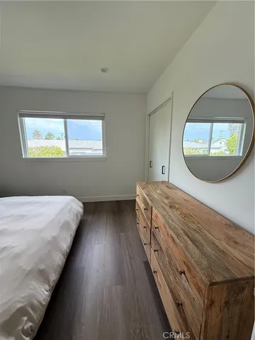 a view of a bedroom with wooden floor and window