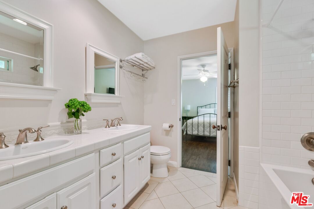811 Jacon Way Pacific Palisades, CA 90272 - Photo 19 of 25 a en suite bathroom with a granite countertop sink a toilet and shower