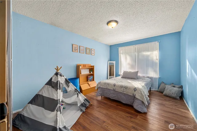 a bedroom with a bed and wooden floor