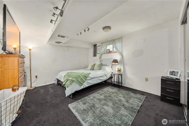 a bedroom with a bed and wooden floor