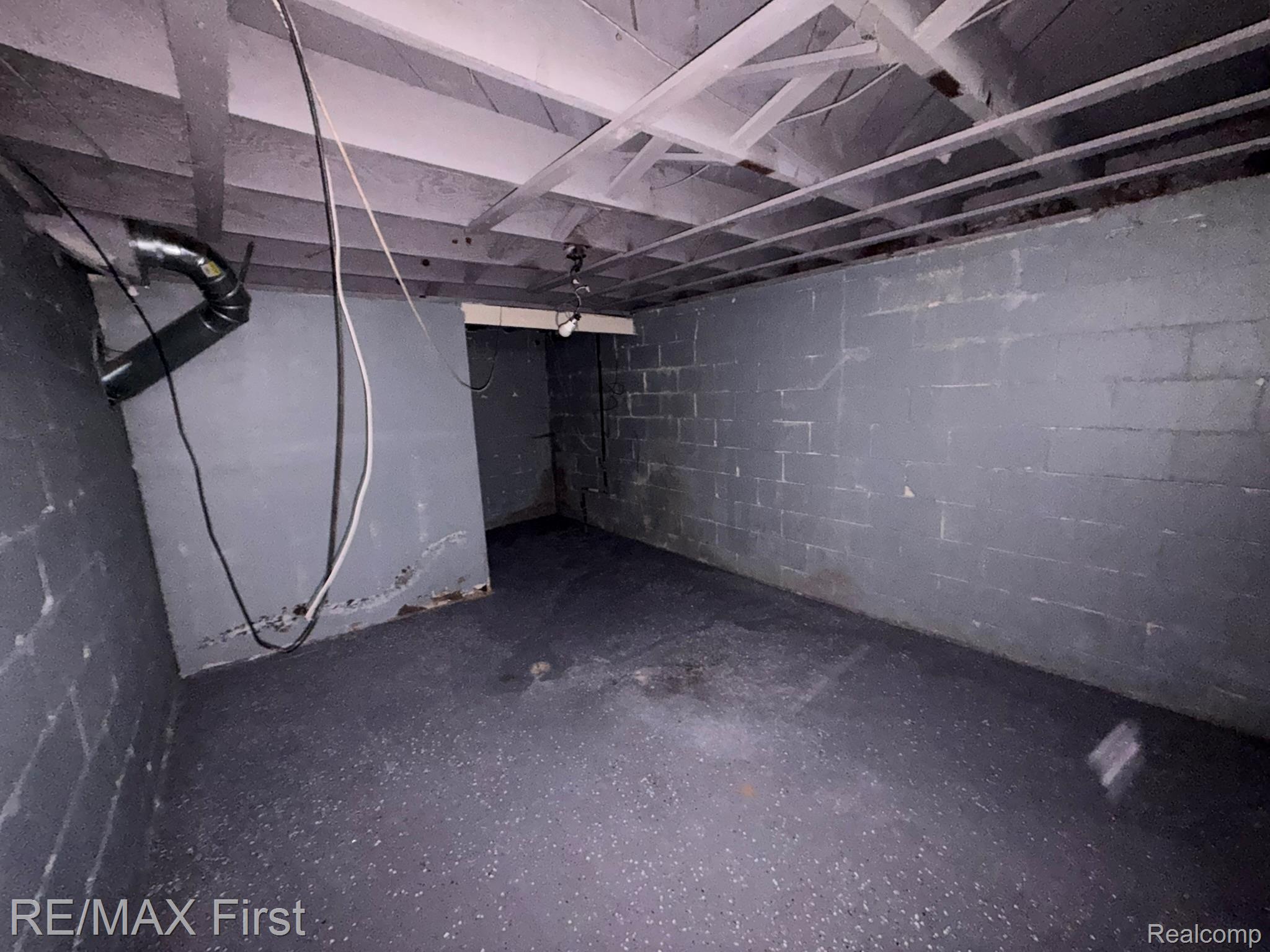 18603 Moross Road Detroit, MI 48224 - Photo 13 of 16 Basement area featuring painted concrete block walls and exposed ceiling joists