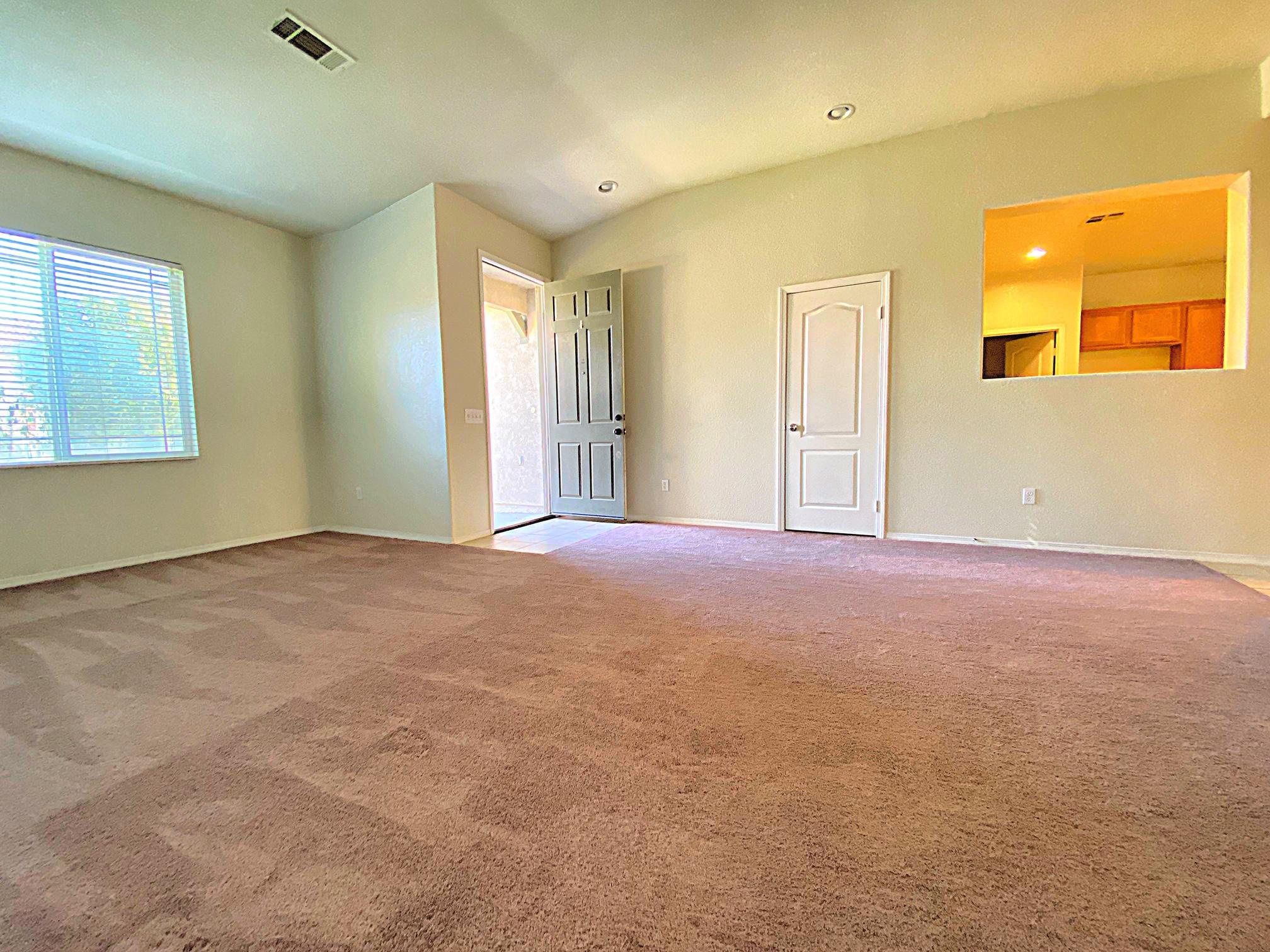 2751 Garnet Lane Lancaster, CA 93535 - Photo 11 of 46 a view of an empty room with window and a kitchen