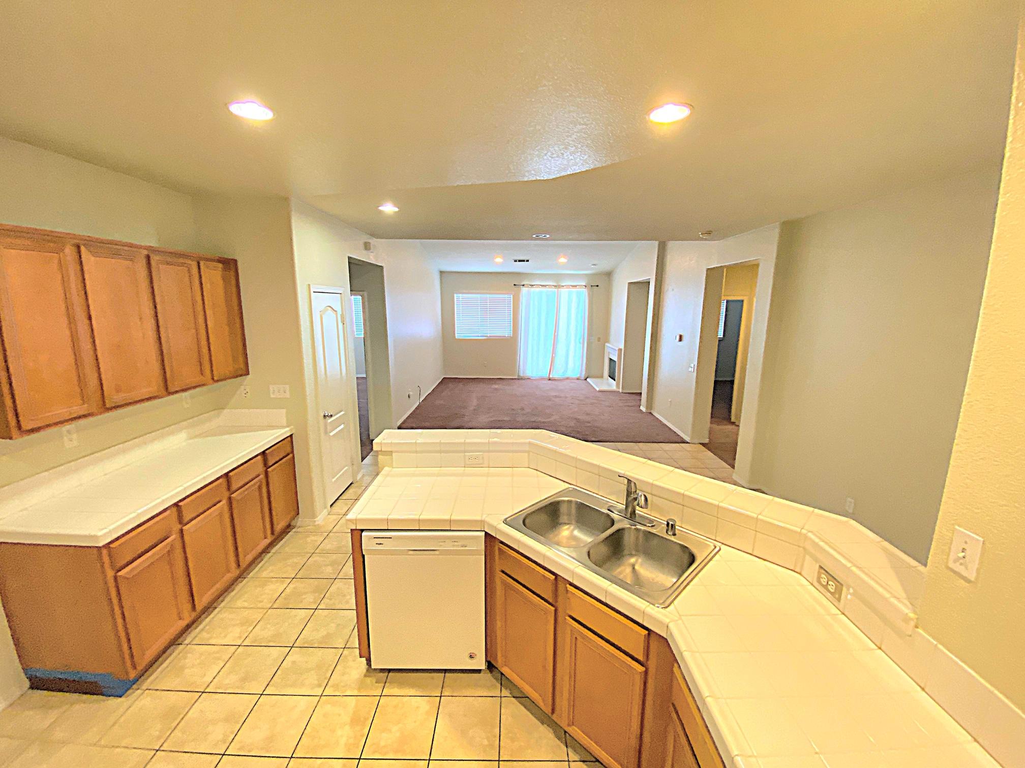 2751 Garnet Lane Lancaster, CA 93535 - Photo 19 of 46 a kitchen with a sink stove and cabinets