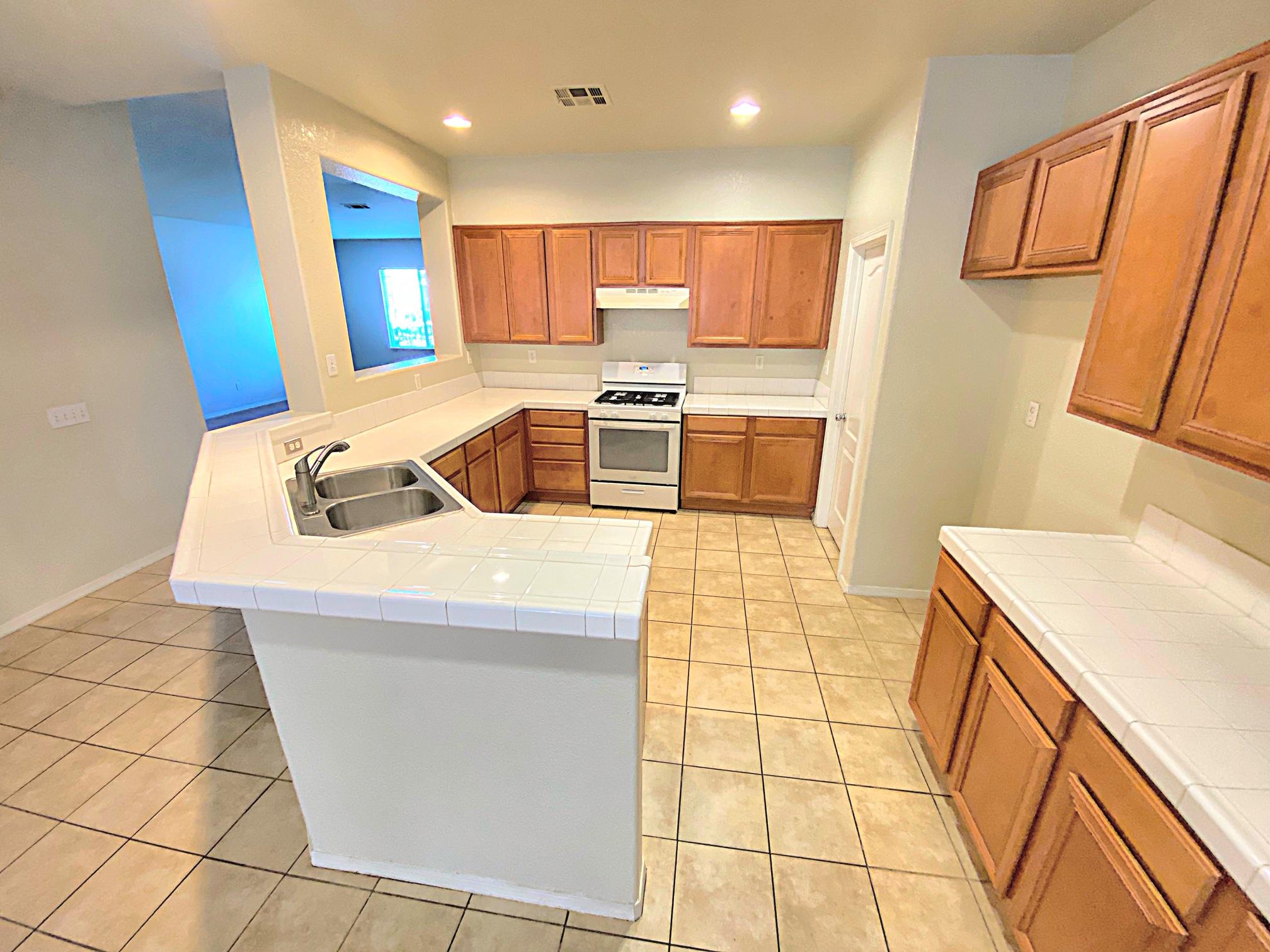 2751 Garnet Lane Lancaster, CA 93535 - Photo 20 of 46 a kitchen with stainless steel appliances a sink a stove top oven a counter space and cabinets