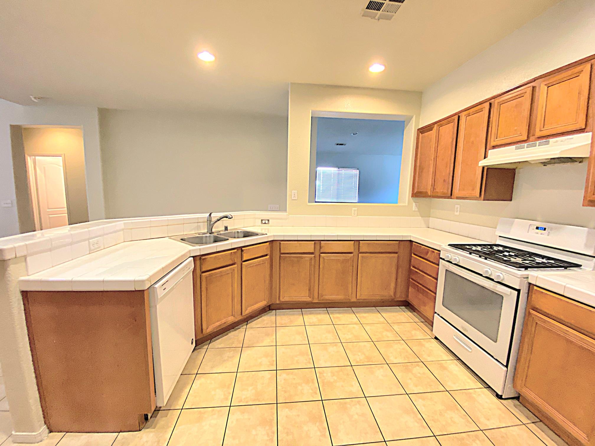 2751 Garnet Lane Lancaster, CA 93535 - Photo 21 of 46 a kitchen with granite countertop a sink a stove top oven and cabinets