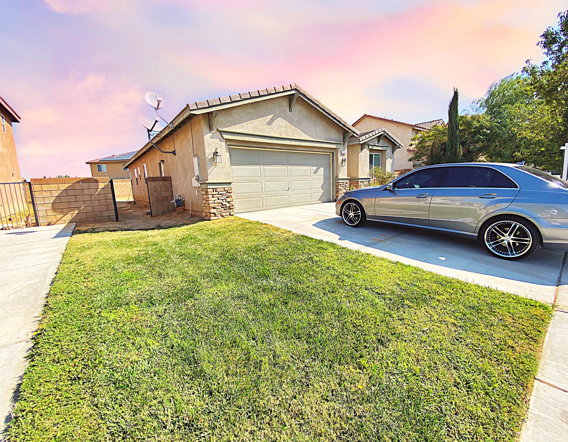 2751 Garnet Lane Lancaster, CA 93535 - Photo 3 of 46 a view of a house with a big yard and large trees