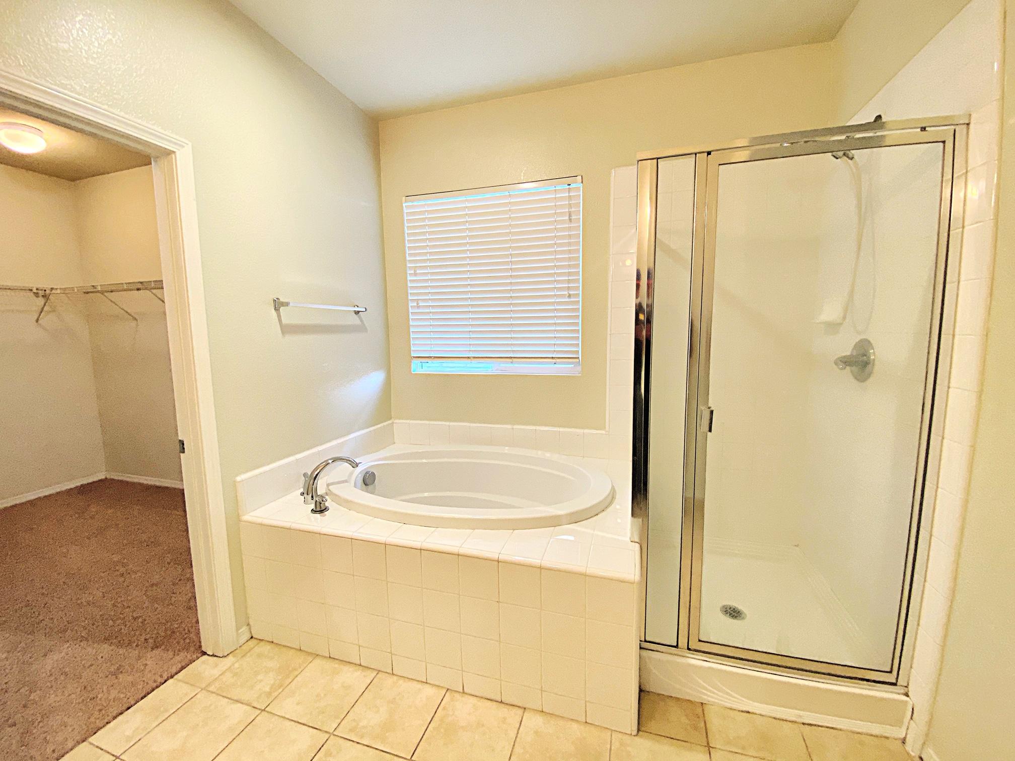 2751 Garnet Lane Lancaster, CA 93535 - Photo 37 of 46 a bathroom with a tub a mirror and a shower