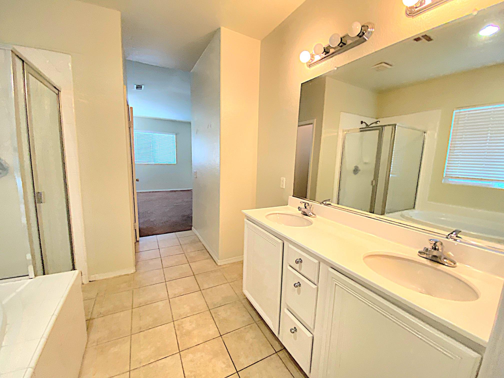 2751 Garnet Lane Lancaster, CA 93535 - Photo 40 of 46 a spacious bathroom with a sink a mirror and a shower
