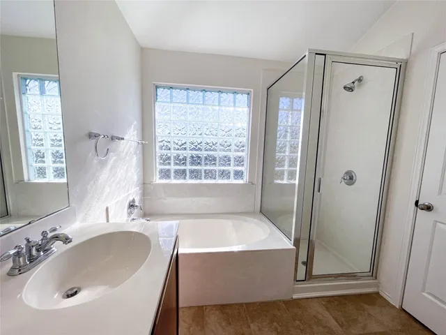 a bathroom with a tub sink and shower