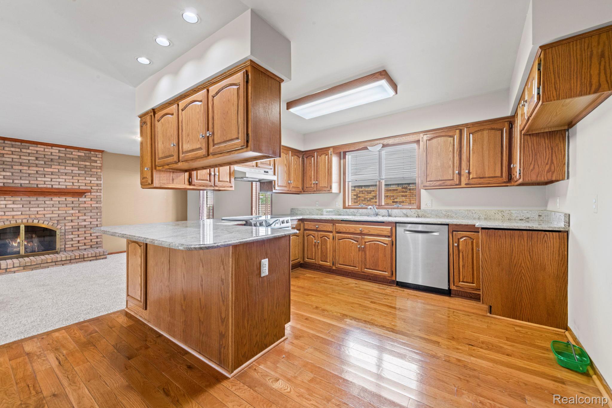 21580 Georgetown Road Trenton, MI 48183 - Photo 11 of 36 Kitchen featuring wood cabinetry, granite-style countertops, stainless steel appliances, and wood-finish flooring