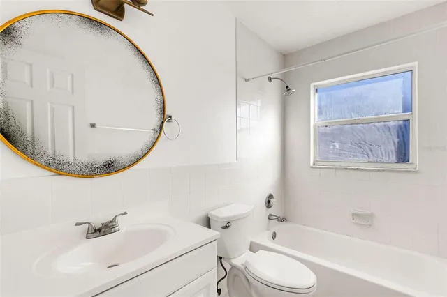 a bathroom with a sink a mirror a toilet and a bathtub