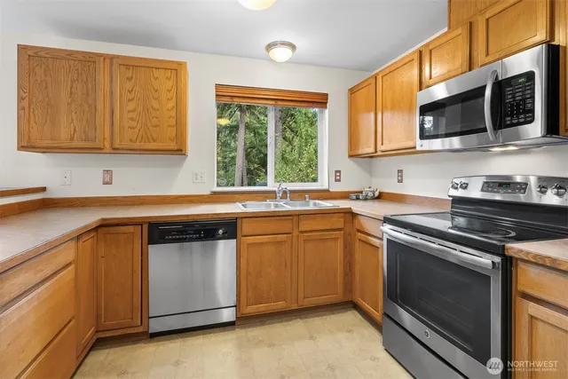 a view of a big room with windows and kitchen view