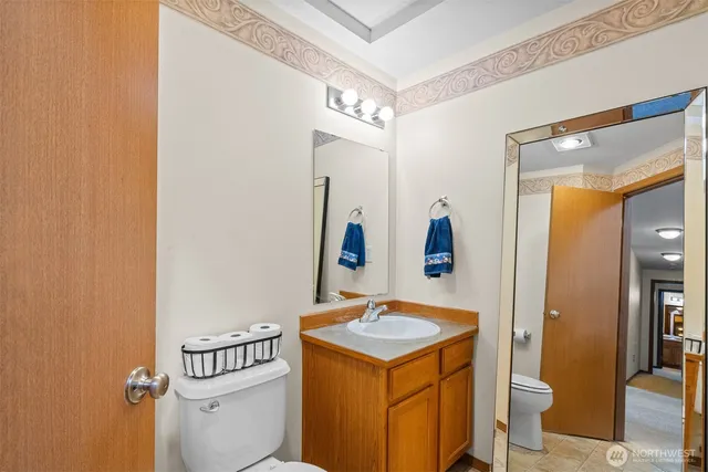 a view of a hallway with bathroom and mirror