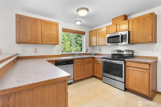 a kitchen with stainless steel appliances a stove sink and microwave