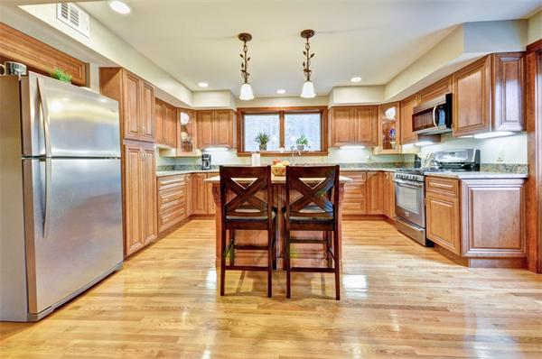119 Pecunit Street Canton, MA 02021 - Photo 3 of 28 a kitchen with stainless steel appliances granite countertop a table chairs refrigerator and sink