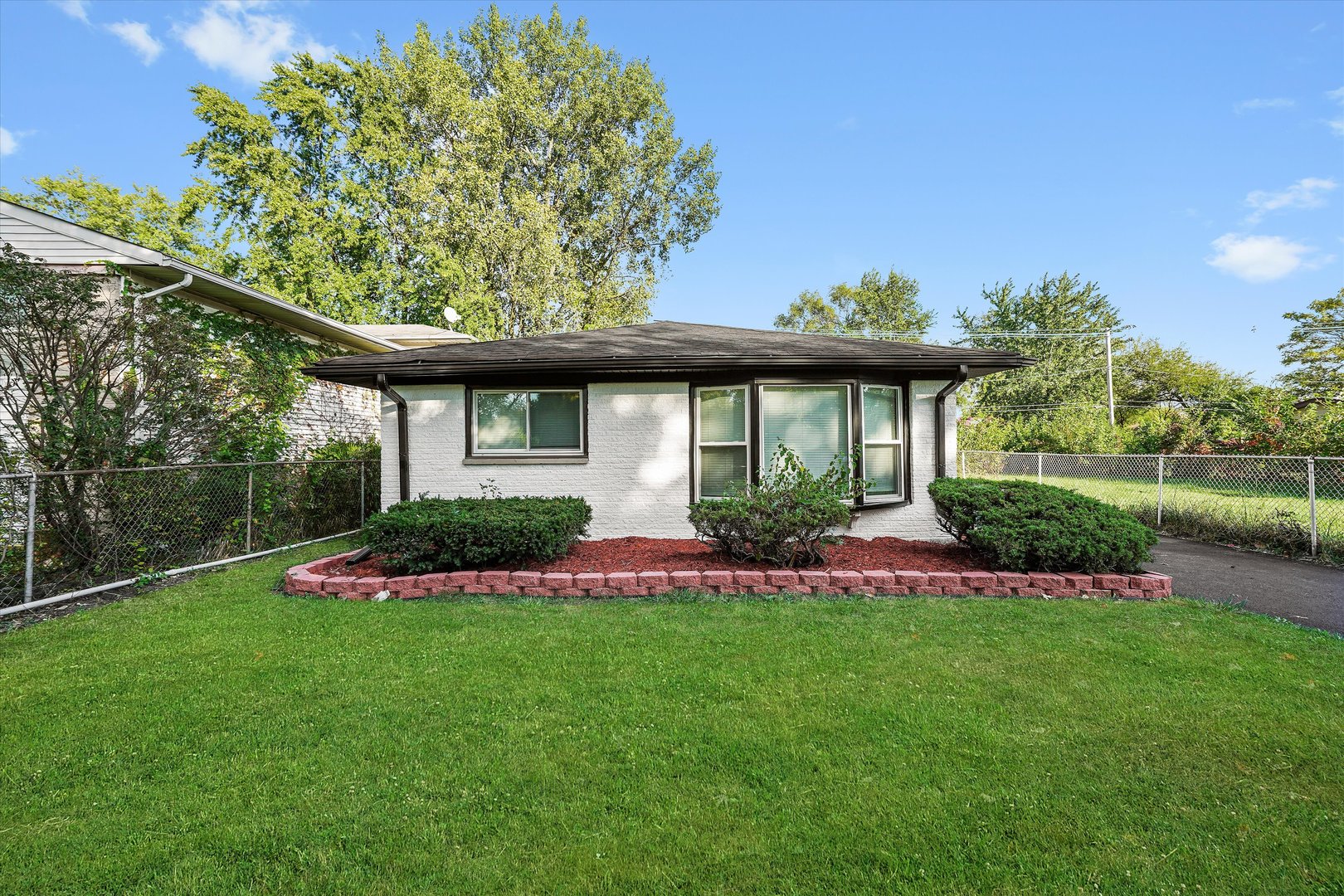 a front view of a house with a yard and potted plants