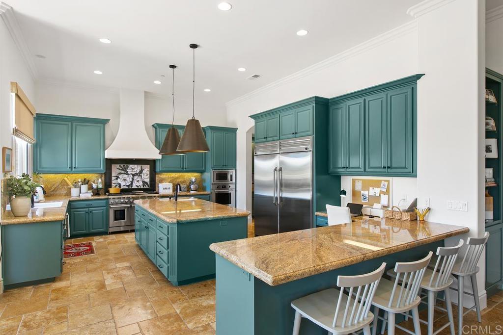 18365 Old Coach Way Poway, CA 92064 - Photo 13 of 55 a kitchen with granite countertop a table chairs stove and refrigerator