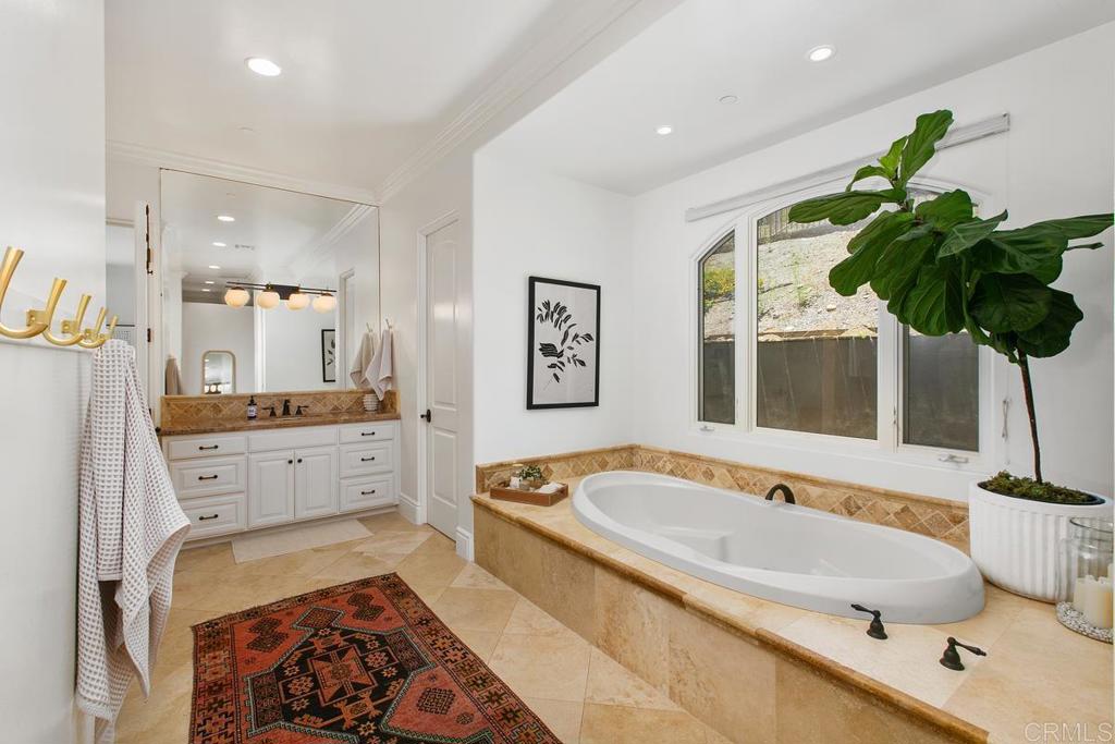 18365 Old Coach Way Poway, CA 92064 - Photo 26 of 55 a spacious bathroom with a tub double sink and a potted plant