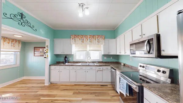 a kitchen with stainless steel appliances granite countertop a sink stove and cabinets
