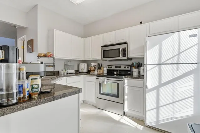 a kitchen with stainless steel appliances granite countertop a sink stove and cabinets