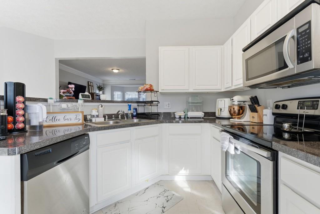 100 Benfield Circle Southeast Cartersville, GA 30121 - Photo 15 of 24 a kitchen with stainless steel appliances granite countertop a sink stove and cabinets