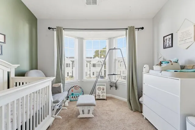 a view of a bedroom with baby crib and furniture