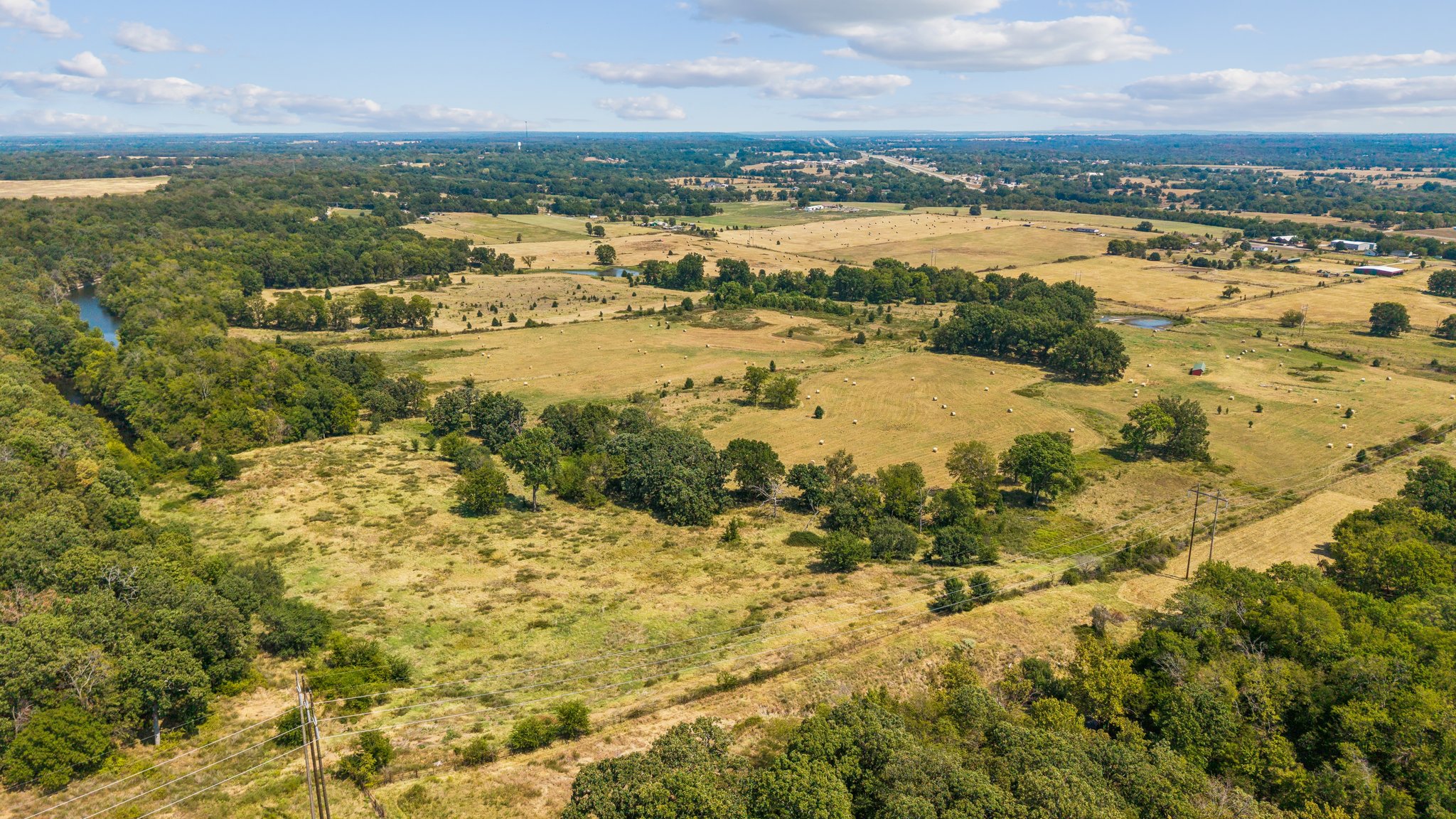 0 East 420 Road Claremore, OK 74017 - Photo 6 of 9 Expansive rural landscape featuring wooded areas, open fields, and a visible water body