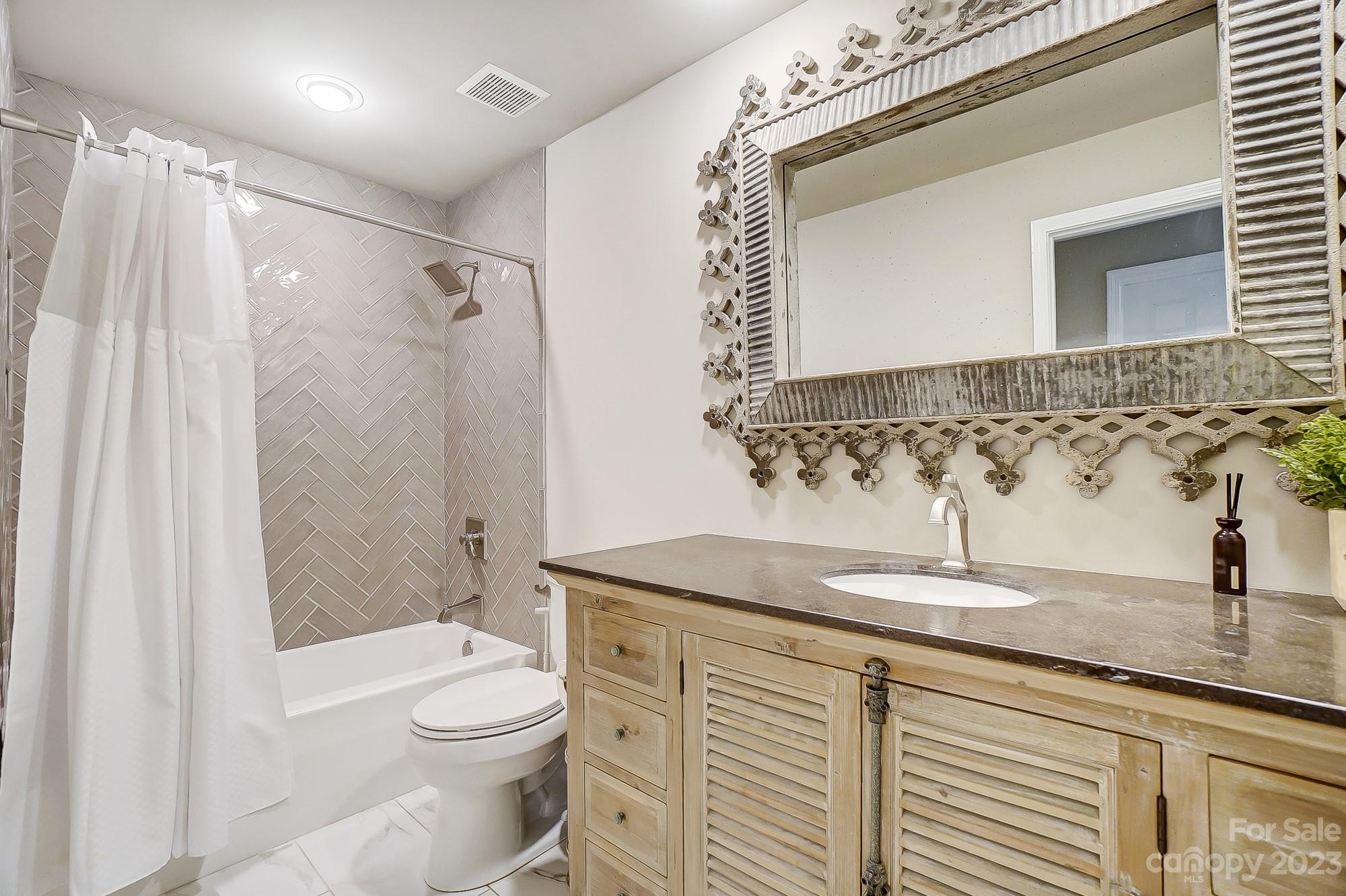 1230 Torrence Circle Davidson, NC 28036 - Photo 19 of 23 a bathroom with a granite countertop sink a toilet and shower