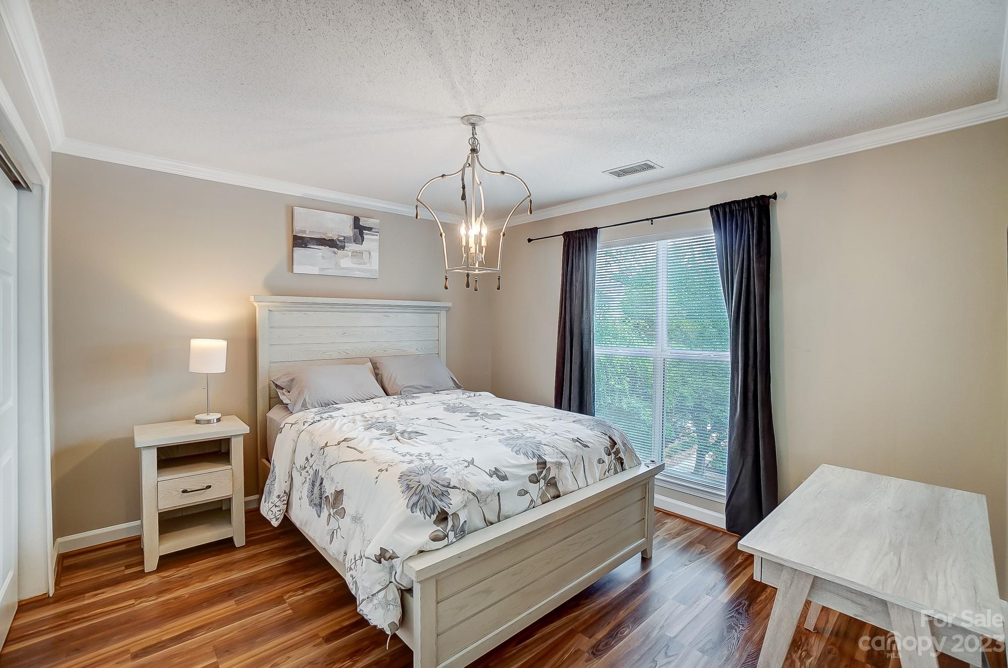1230 Torrence Circle Davidson, NC 28036 - Photo 20 of 23 a bedroom with a bed wooden floor and a window