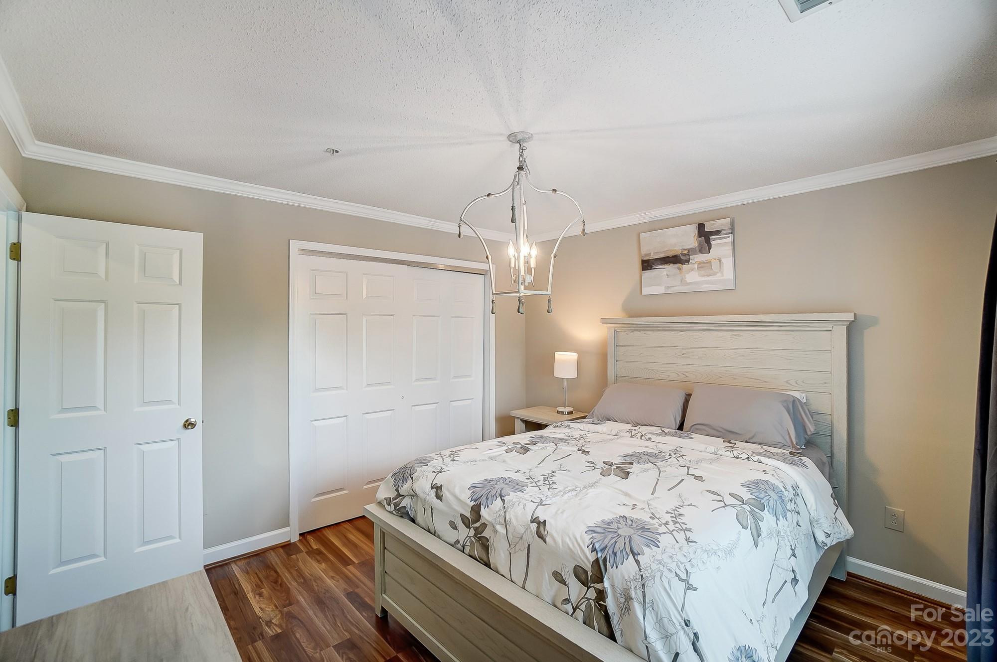 1230 Torrence Circle Davidson, NC 28036 - Photo 21 of 23 a bedroom with a bed and a chandelier