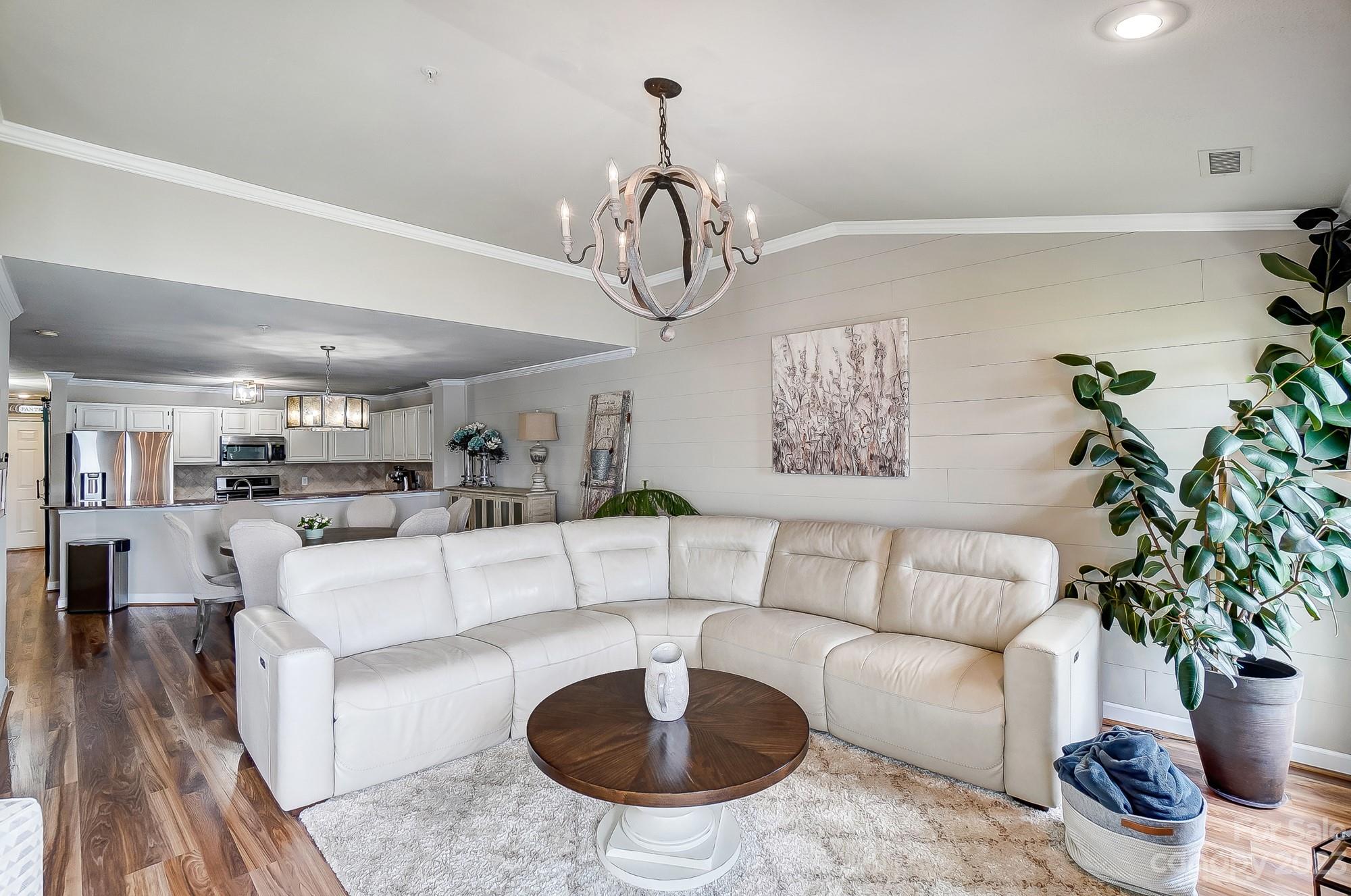1230 Torrence Circle Davidson, NC 28036 - Photo 6 of 23 a living room with furniture a chandelier and a rug