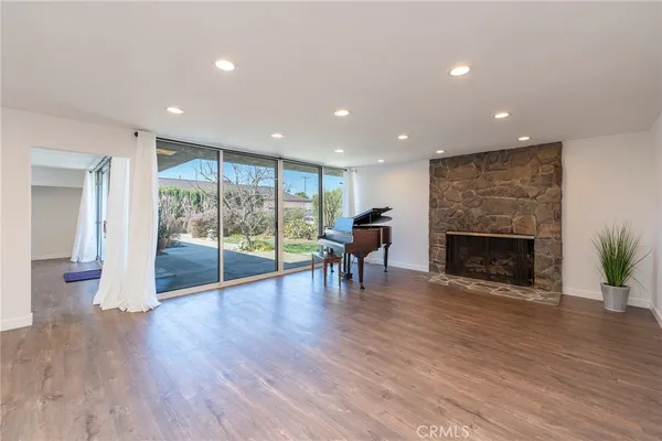 a view of a livingroom with wooden floor and a fireplace