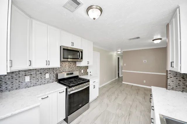an empty room with wooden floor and ceiling fan