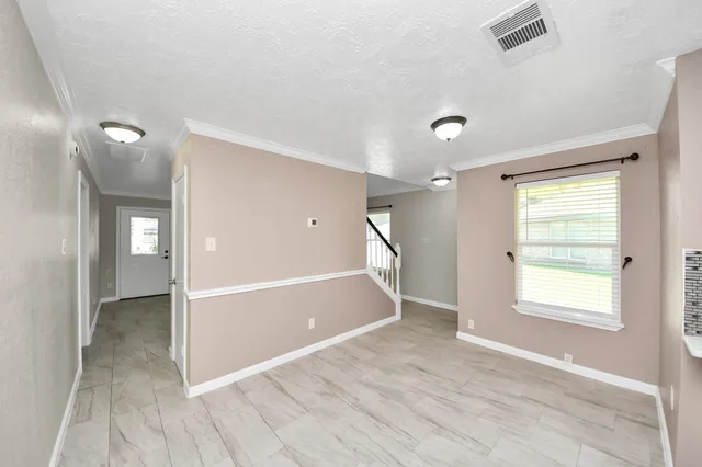 a view of an empty room with wooden floor