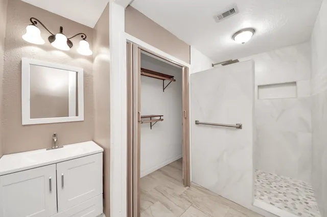 a view of an empty room with wooden floor and window