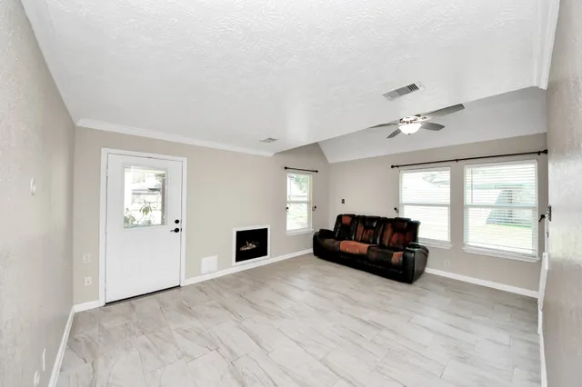a view of a livingroom with wooden floor and a ceiling fan