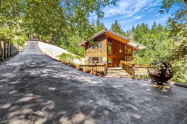 a view of a small house with wooden fence
