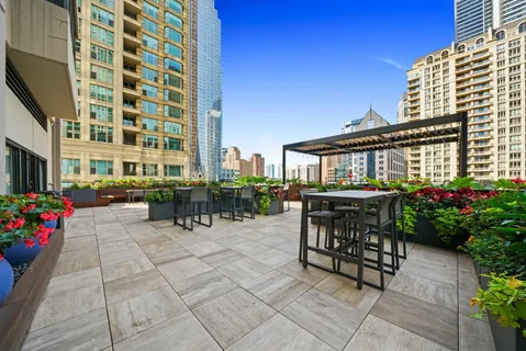 a view of a patio with dining table and chairs and potted plants