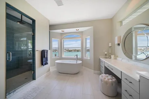 a white bath tub sitting in a bathroom next to a window