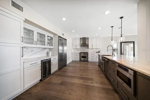 a large kitchen with stainless steel appliances granite countertop a stove top oven a sink and dishwasher