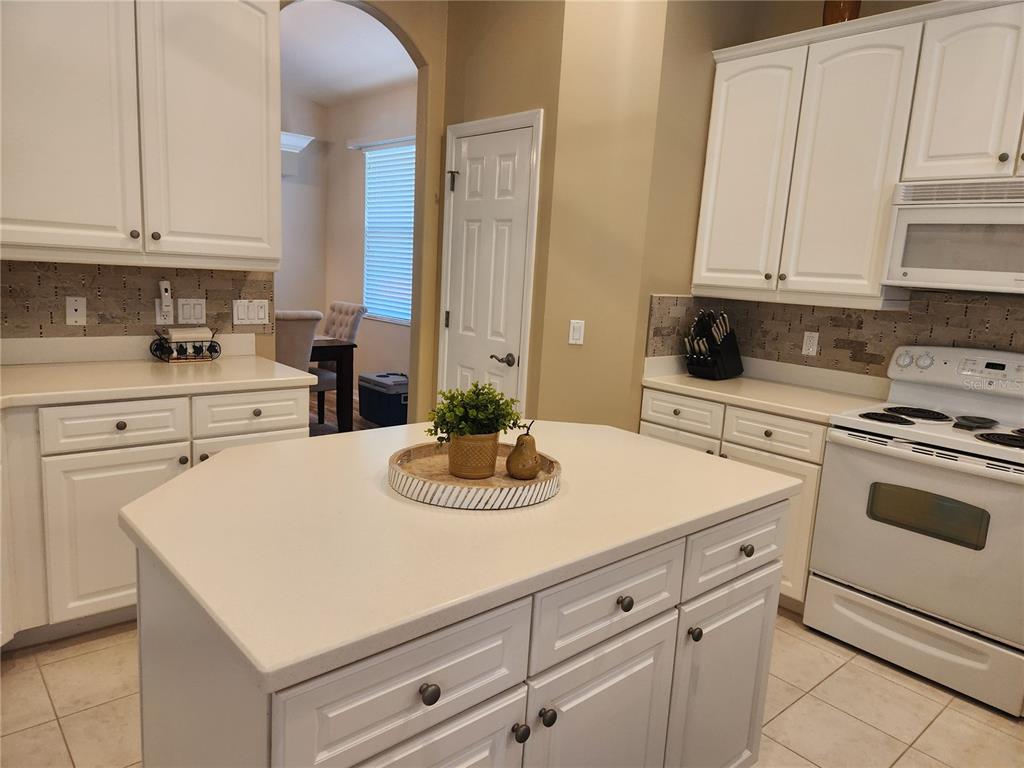 6496 Rookery Circle Bradenton, FL 34203 - Photo 13 of 40 a kitchen with white cabinets and white appliances