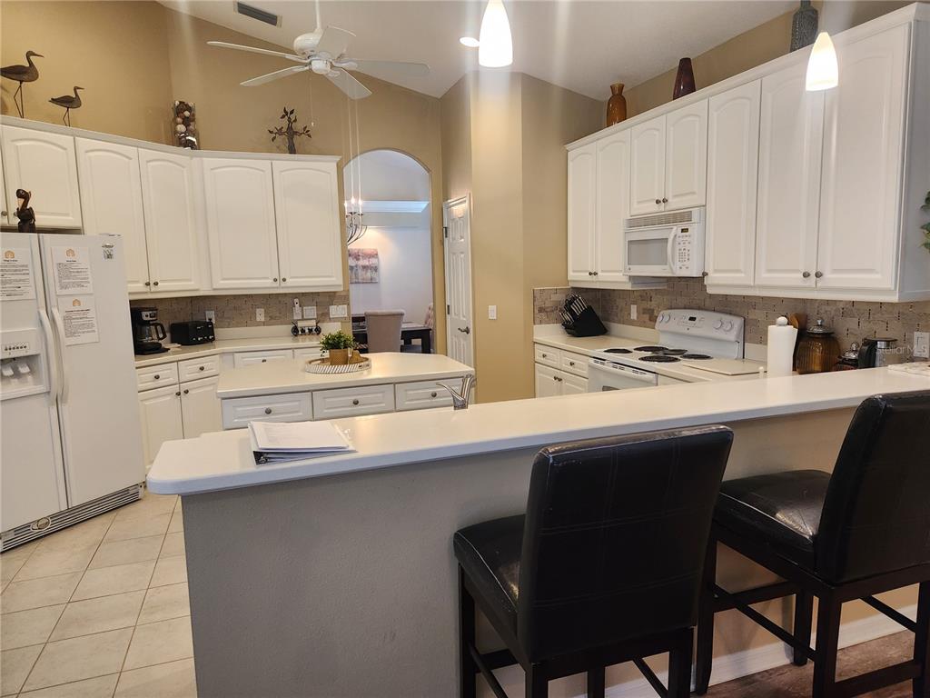 6496 Rookery Circle Bradenton, FL 34203 - Photo 14 of 40 a kitchen with a sink white cabinets and white appliances