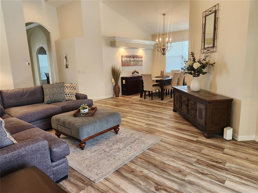 6496 Rookery Circle Bradenton, FL 34203 - Photo 6 of 40 a living room with furniture and a chandelier